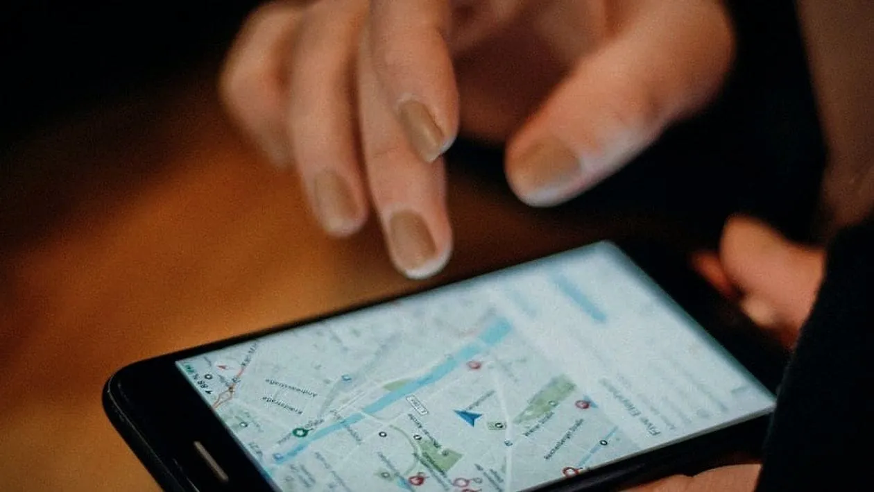 A finger tapping a map on a phone screen.