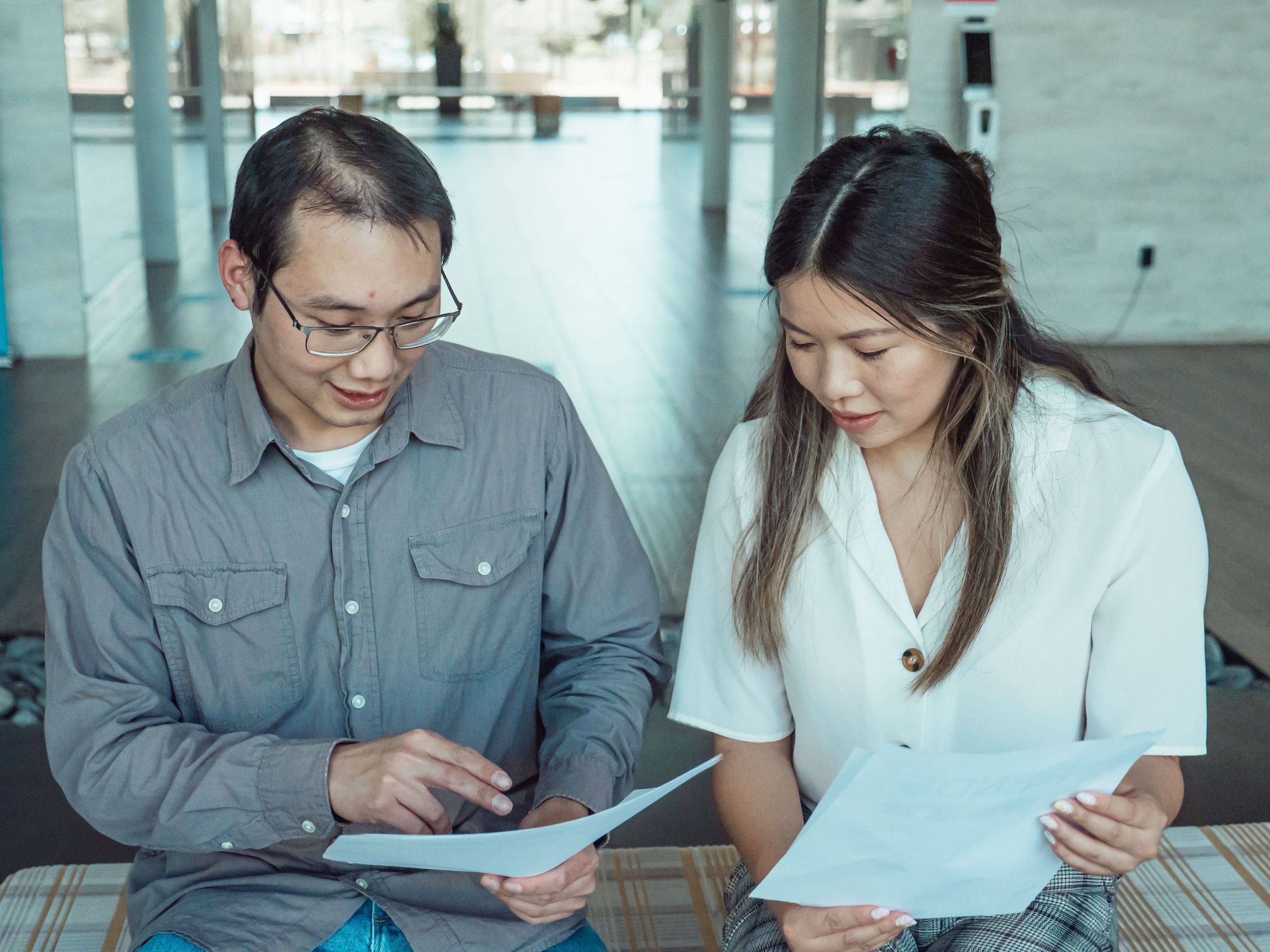 Two specialists sit side by side going through the pages of a case
